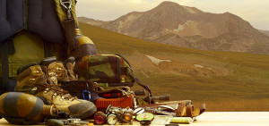 Walking boots and camping gear in front of a Lake District hill