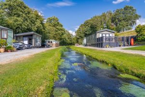 Modern holiday lodges set alongside a clear stream at our Lake District caravan park.