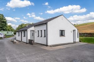 Modern white-rendered shower and toilet block providing facilities for touring guests.