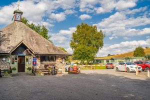 Stone-built reception office with weathervane, welcoming arrivals to the caravan park.